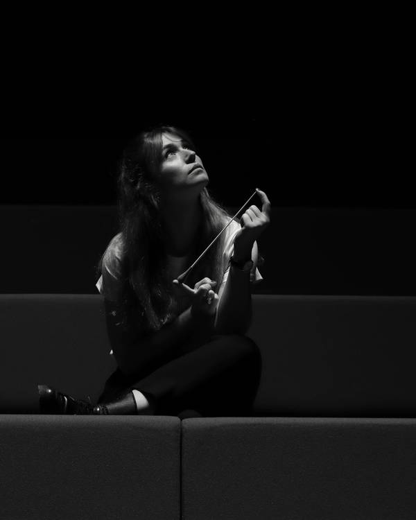 Ambre Jude, baguette de cheffe d'orchestre à la main