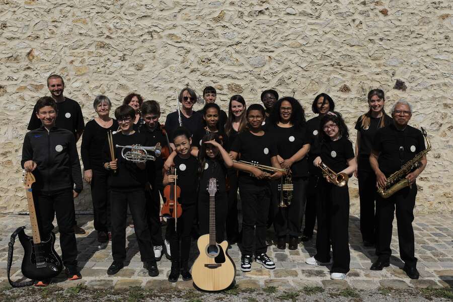 Photo de groupe des stagiaires devant le mur de pierre de la Ferme des Tournelles